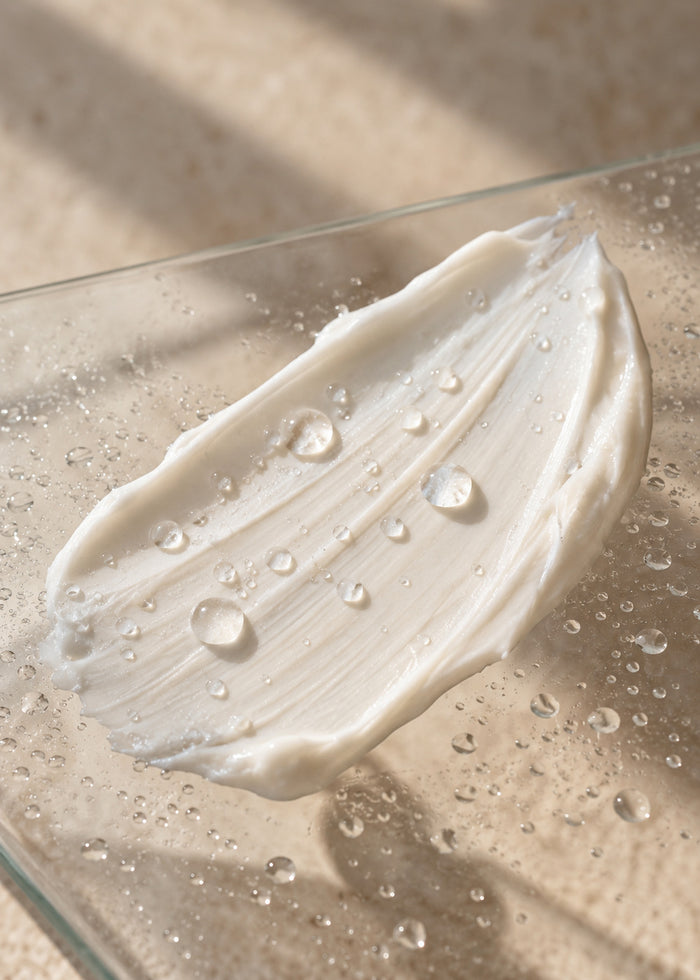Ein dicker Strich Maske auf Glas, darauf feine Wassertropfen.