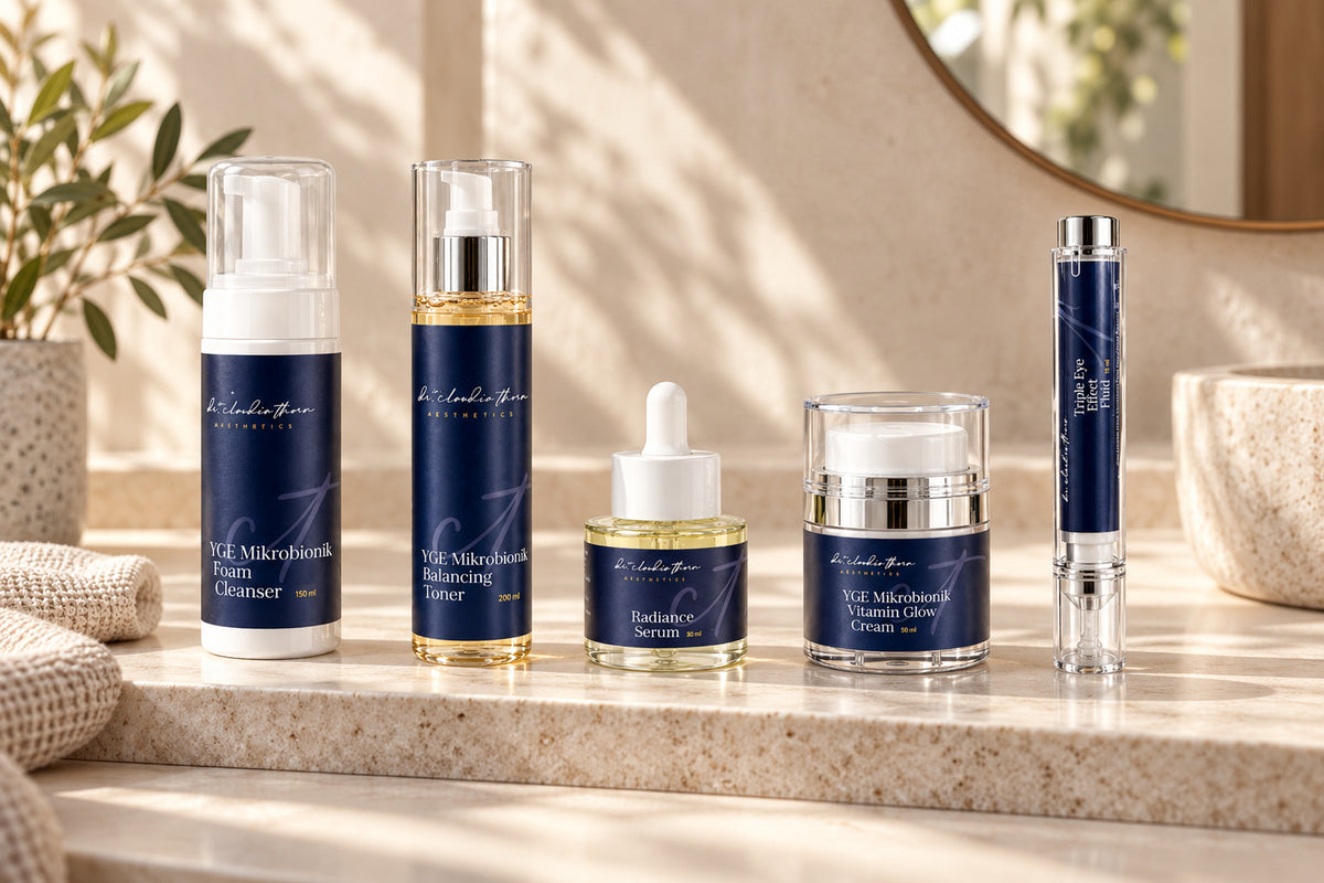 Fünf Produkte der Aesthetics-Linie in einer Reihe auf einer Badezimmerablage.